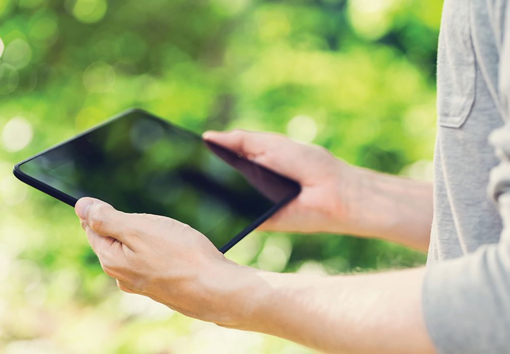 person using a tablet to control outdoor lighting