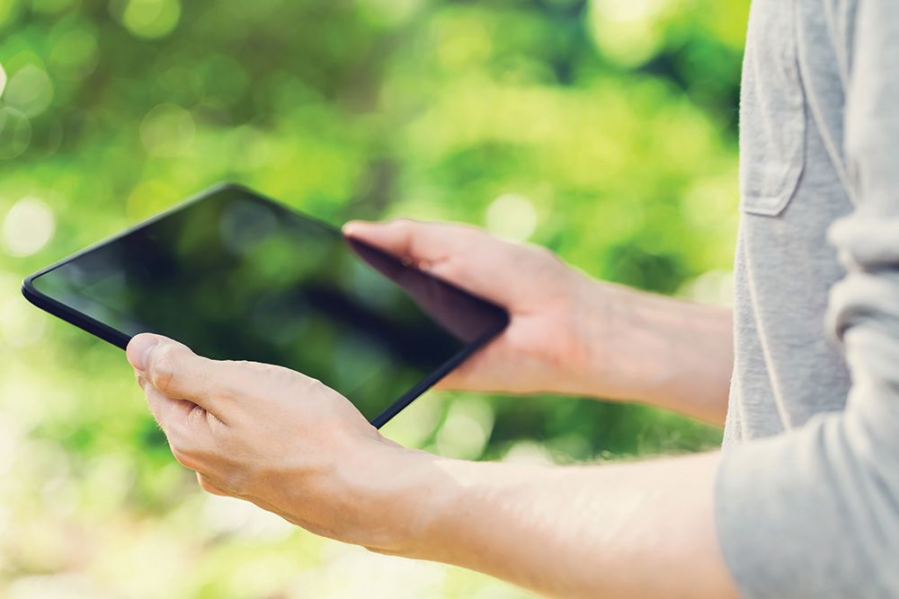 person using a tablet to control outdoor lighting