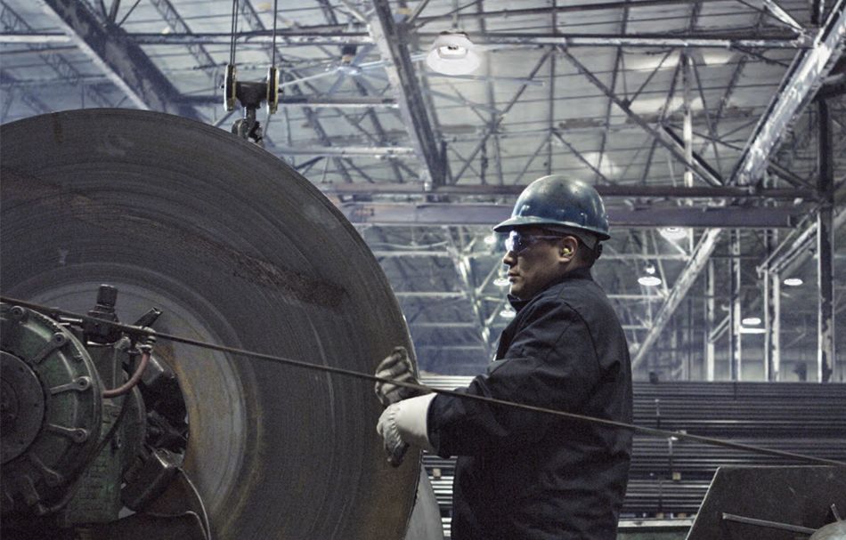 man working in a factory with high-bay lighting