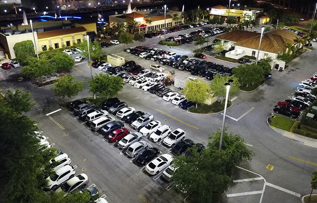 An aerial view of the outdoor LED lighting at The Palms Town Country building and parking lot at night