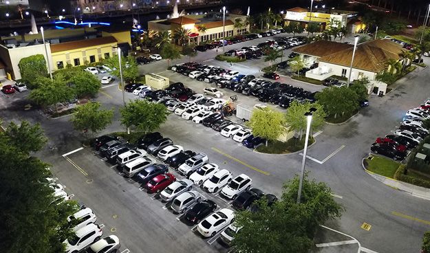 An aerial view of the outdoor LED lighting at The Palms Town Country building and parking lot at night