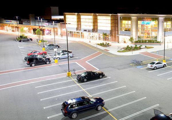 Retail store parking lot that is well lit with storefront lighting fixtures