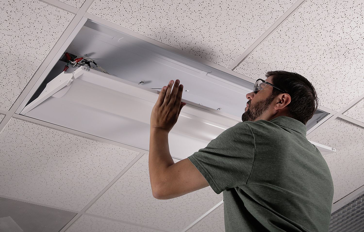 contractor installing zrrk retrofit troffer in drop ceiling